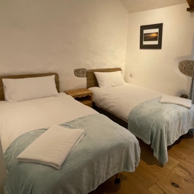 Photo of twin bedroom at Trengothal Barn holiday let with white linen