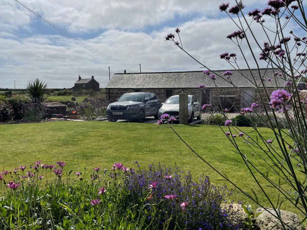 Photo of front garden and cars parked outside Trengothal Barn